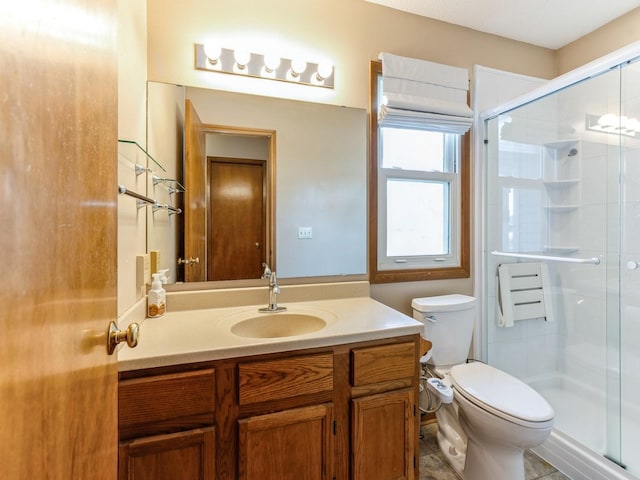 bathroom featuring a stall shower, vanity, and toilet