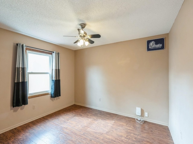 empty room with a ceiling fan, a textured ceiling, baseboards, and wood finished floors