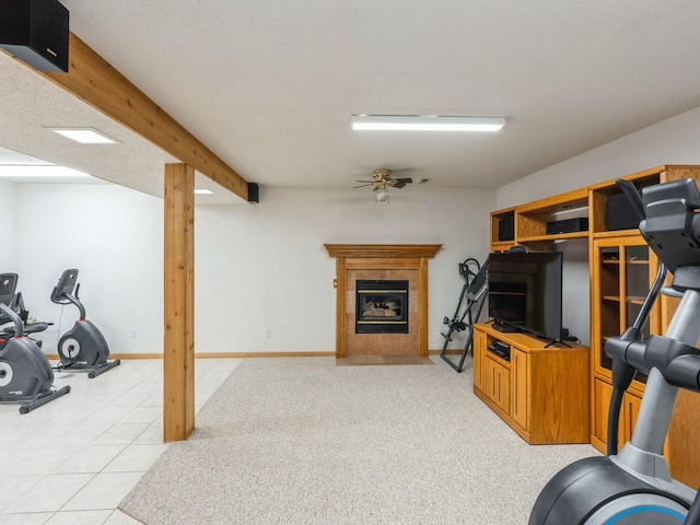 workout area with a fireplace, baseboards, a textured ceiling, and light tile patterned flooring