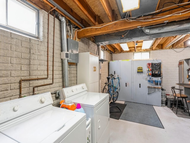 laundry area featuring plenty of natural light, laundry area, independent washer and dryer, and brick wall