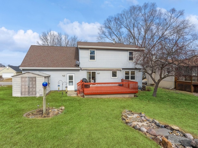 rear view of property featuring a storage shed, a shingled roof, a lawn, an outbuilding, and a deck