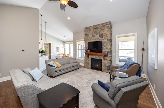 living area featuring vaulted ceiling, baseboards, and wood finished floors