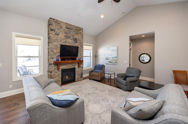 living room featuring ceiling fan, high vaulted ceiling, a fireplace, wood finished floors, and baseboards