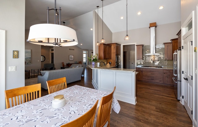 dining space with dark wood-style floors, high vaulted ceiling, and recessed lighting