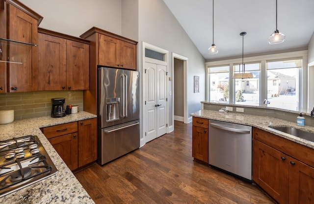 kitchen featuring stainless steel appliances, brown cabinetry, and a sink