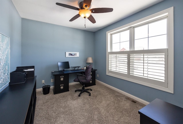 carpeted office with baseboards, visible vents, and ceiling fan