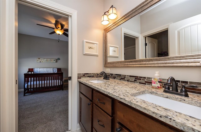 full bath with double vanity, a ceiling fan, decorative backsplash, and a sink