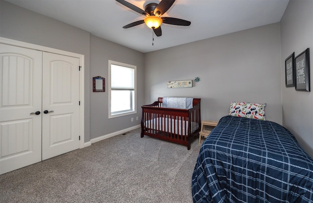 carpeted bedroom with a ceiling fan, a closet, and baseboards