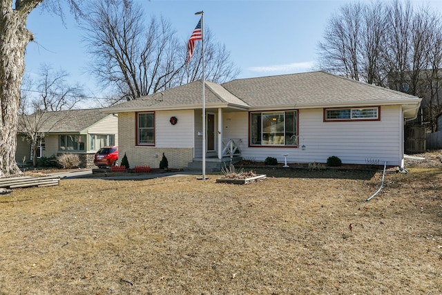 ranch-style house with a shingled roof and brick siding