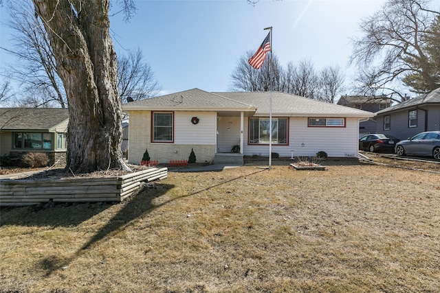 view of front of home featuring brick siding and a front yard