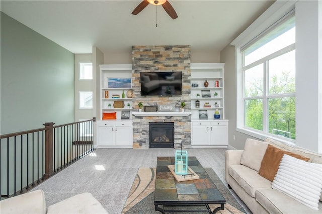 living area with light colored carpet, a fireplace, and ceiling fan