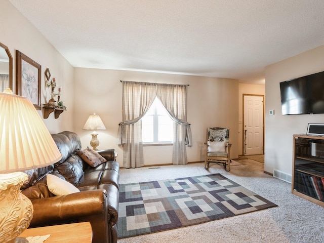 carpeted living room with visible vents, a textured ceiling, and baseboards