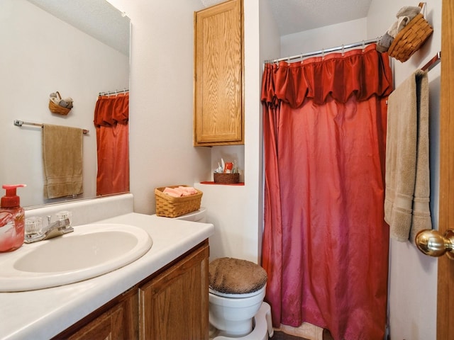 bathroom with a shower with shower curtain, vanity, and toilet