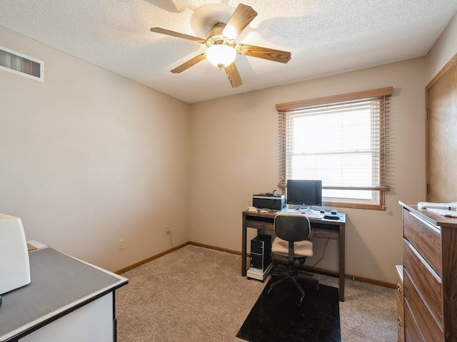 office with visible vents, ceiling fan, light carpet, and a textured ceiling