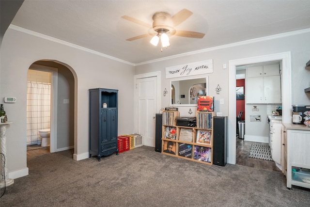 interior space with arched walkways, crown molding, carpet, and ceiling fan