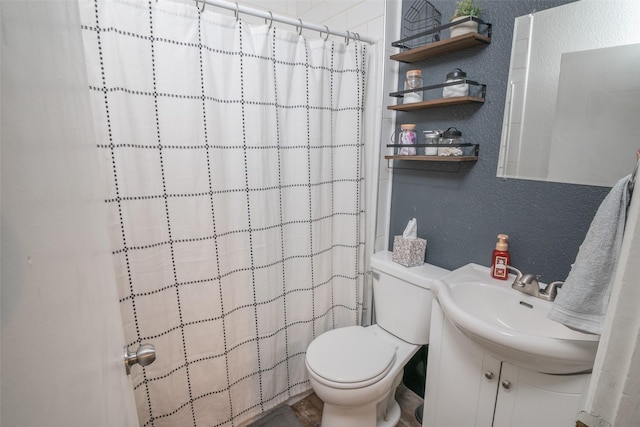 full bathroom featuring a textured wall, a shower with shower curtain, vanity, and toilet