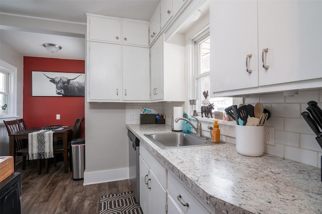 kitchen featuring light countertops, decorative backsplash, white cabinets, a sink, and dishwasher