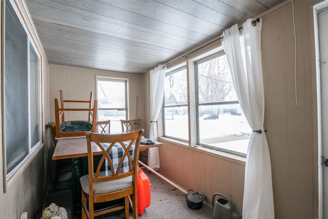 carpeted dining area featuring wood ceiling