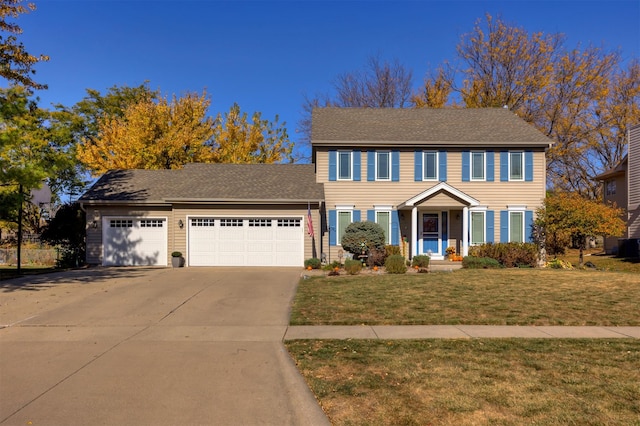 colonial house featuring a garage, a front yard, and concrete driveway