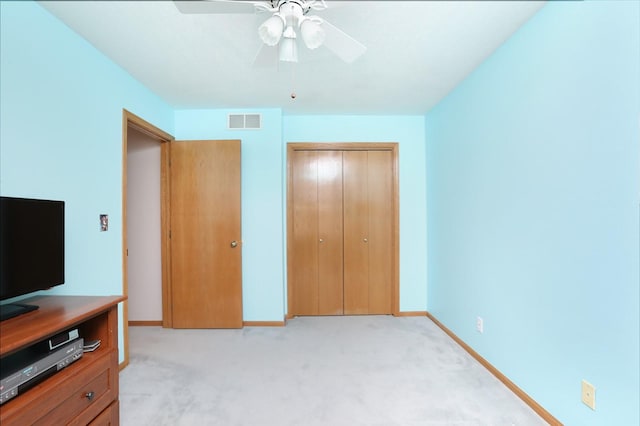 unfurnished bedroom with ceiling fan, light colored carpet, baseboards, visible vents, and a closet
