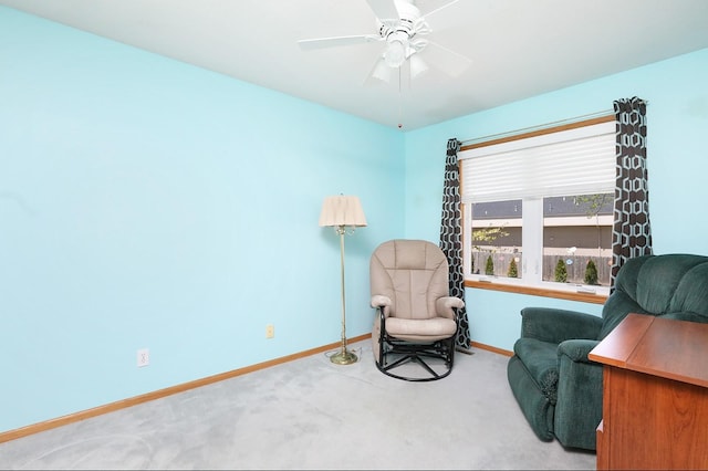 living area featuring carpet floors, baseboards, and ceiling fan
