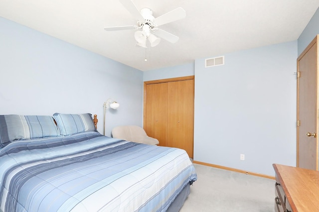 bedroom with a ceiling fan, visible vents, baseboards, a closet, and light carpet
