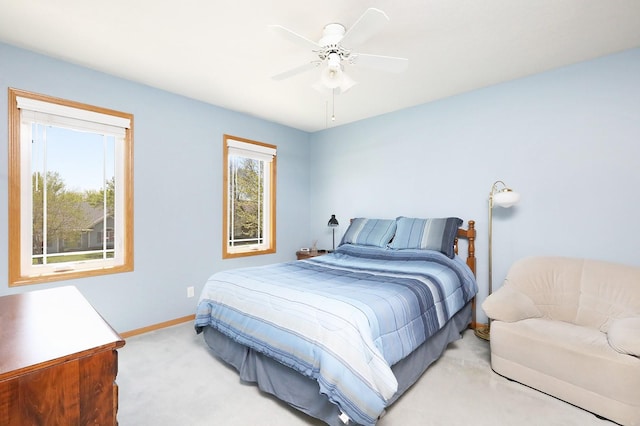 bedroom with baseboards, a ceiling fan, and light carpet