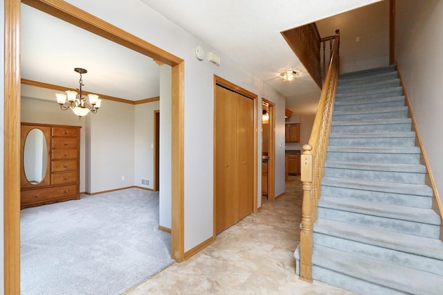 stairway with baseboards, visible vents, and a notable chandelier