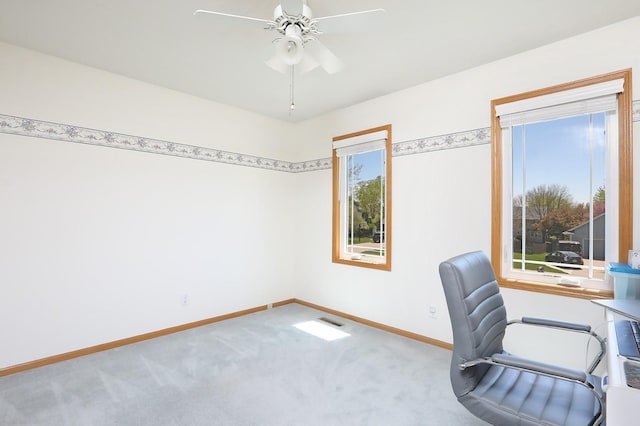 unfurnished office with carpet floors, baseboards, visible vents, and ceiling fan
