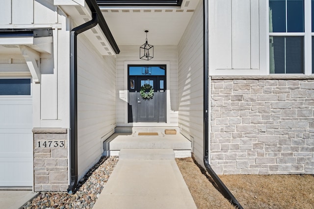 entrance to property with board and batten siding and a garage