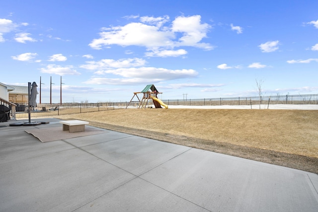 community playground with a yard, a patio area, and a fenced backyard