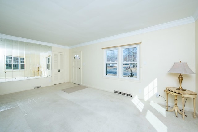 entrance foyer with carpet floors, ornamental molding, visible vents, and baseboards