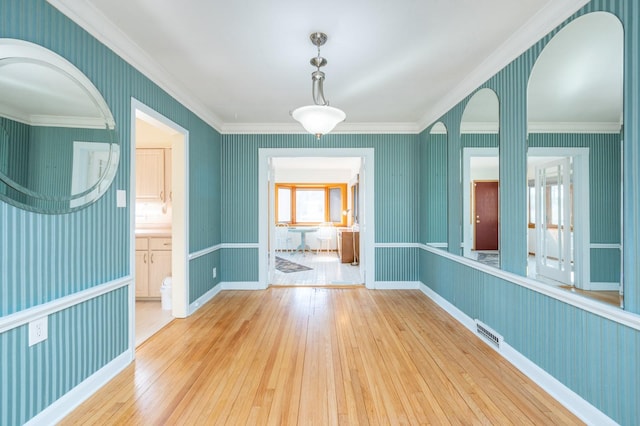 spare room with ornamental molding, visible vents, hardwood / wood-style floors, and wallpapered walls