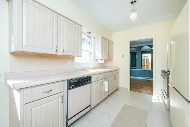 kitchen featuring a sink, light countertops, dishwasher, and freestanding refrigerator