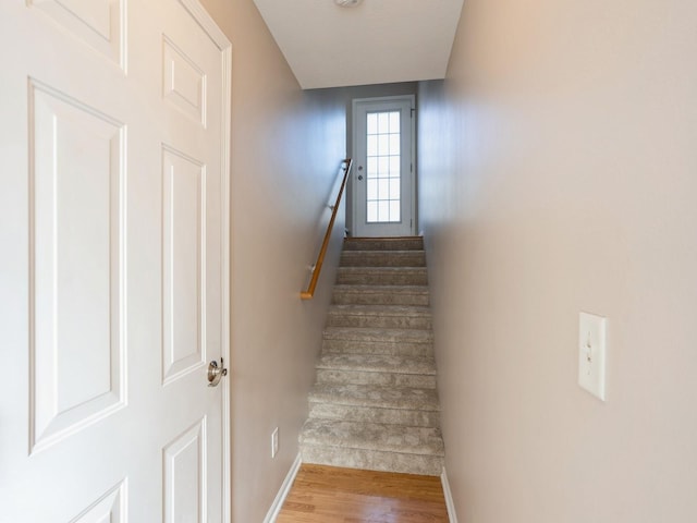 stairway featuring baseboards and wood finished floors