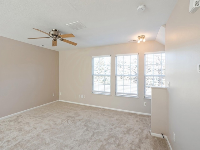 carpeted spare room featuring baseboards, visible vents, and a ceiling fan