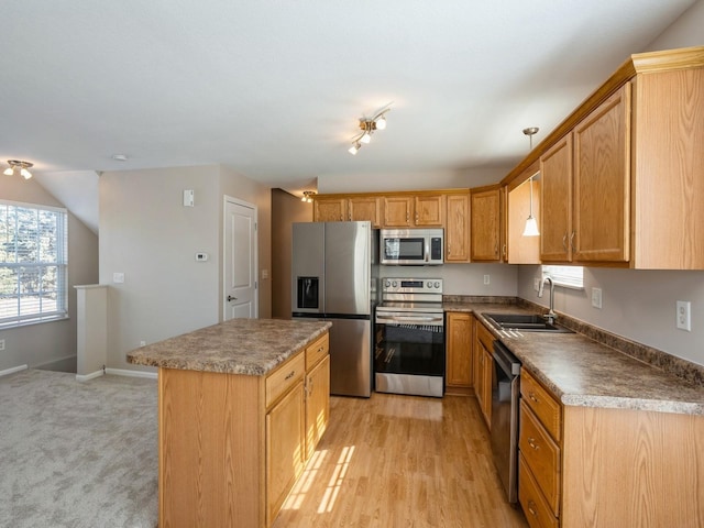 kitchen featuring baseboards, a kitchen island, appliances with stainless steel finishes, light wood-style floors, and a sink