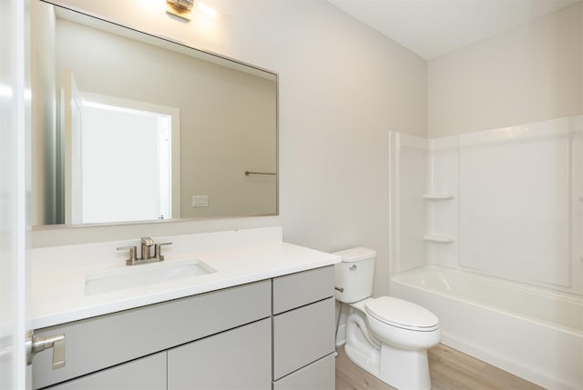 bathroom featuring toilet, bathing tub / shower combination, wood finished floors, and vanity