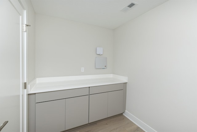 bathroom with baseboards, visible vents, and wood finished floors