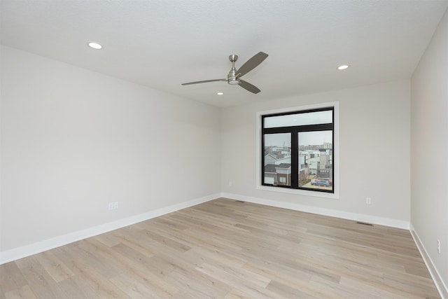 unfurnished room with light wood-style floors, recessed lighting, and baseboards