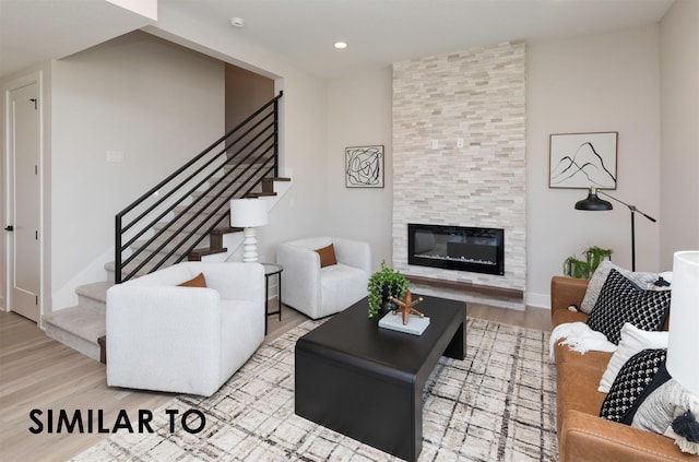 living room featuring stairs, a fireplace, wood finished floors, and recessed lighting