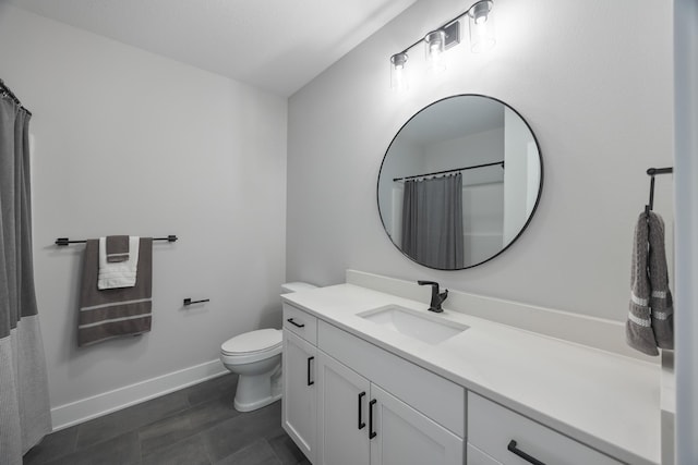 bathroom with toilet, baseboards, and vanity