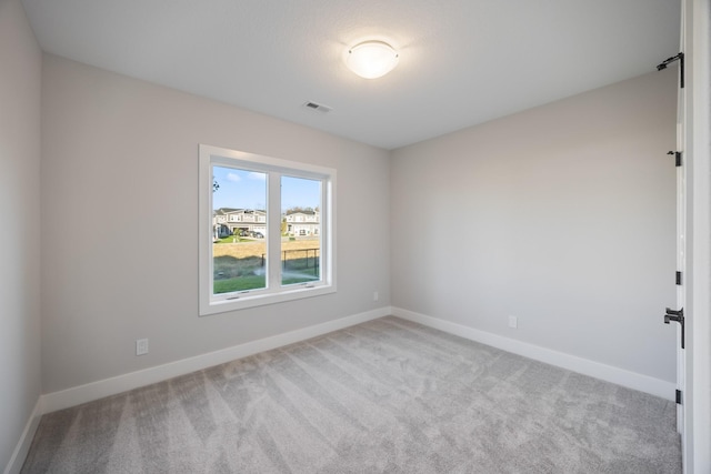 unfurnished room featuring carpet floors, visible vents, and baseboards