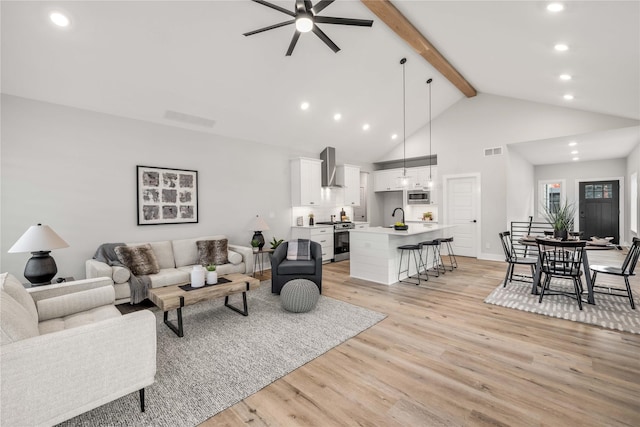 living room with high vaulted ceiling, light wood-style flooring, beam ceiling, and visible vents