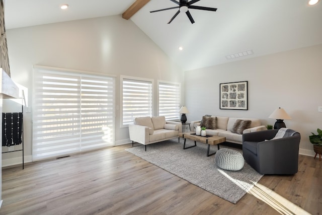 living room featuring visible vents, beam ceiling, high vaulted ceiling, and wood finished floors