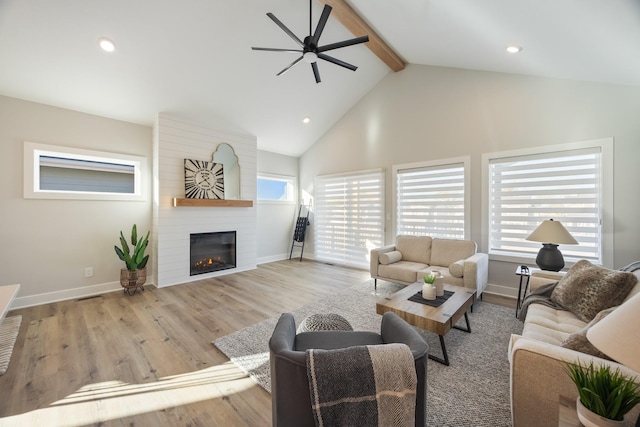 living room featuring baseboards, wood finished floors, a fireplace, high vaulted ceiling, and beam ceiling