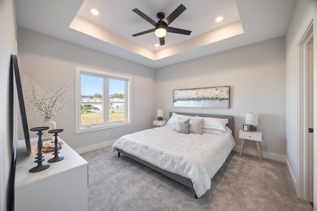 bedroom featuring a tray ceiling, recessed lighting, carpet flooring, and baseboards