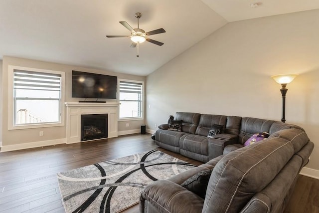 living room featuring dark wood-style flooring, a fireplace, vaulted ceiling, and baseboards