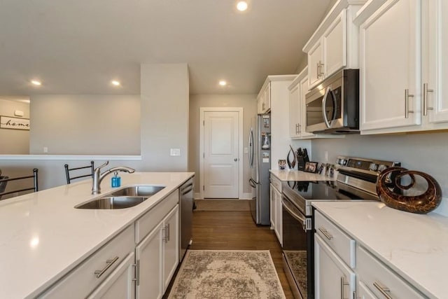 kitchen featuring white cabinets, appliances with stainless steel finishes, light countertops, and a sink