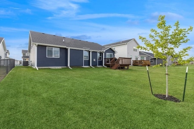 rear view of property with cooling unit, fence, a lawn, and a wooden deck